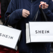 Shopper carrying two SHEIN shopping bags
