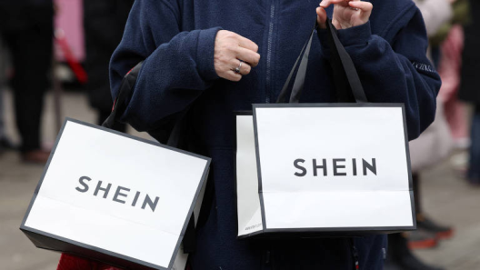 Shopper carrying two SHEIN shopping bags